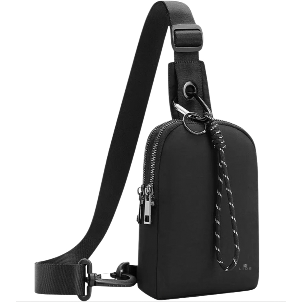 A black sling bag with an adjustable strap, zippered main compartment, and decorative cord detail, designed for carrying essentials.