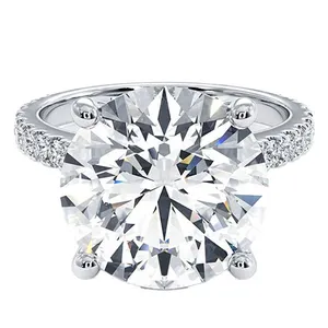 A round-cut diamond ring with a large center stone set in a four-prong setting, featuring a pavé diamond band on a silver or white gold metal.