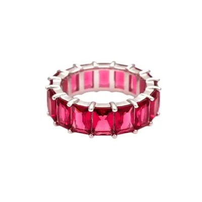 A silver ring featuring a continuous row of rectangular, vibrant pink gemstones, set in a prong setting for an elegant eternity design.