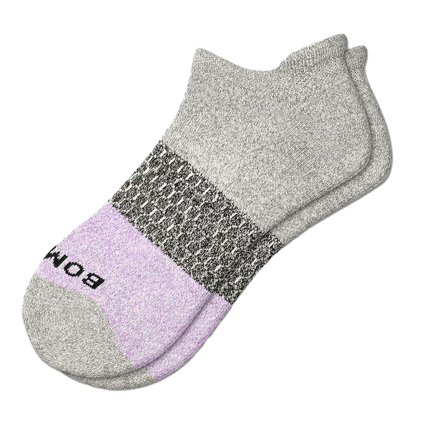 A pair of Bombas ankle socks with gray, black, and purple color blocks. The toe area features the brand name \“Bombas\“ in black text.
