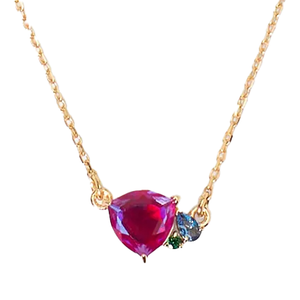 A gold necklace featuring a vibrant red gemstone at the center, accompanied by smaller blue and green stones.
