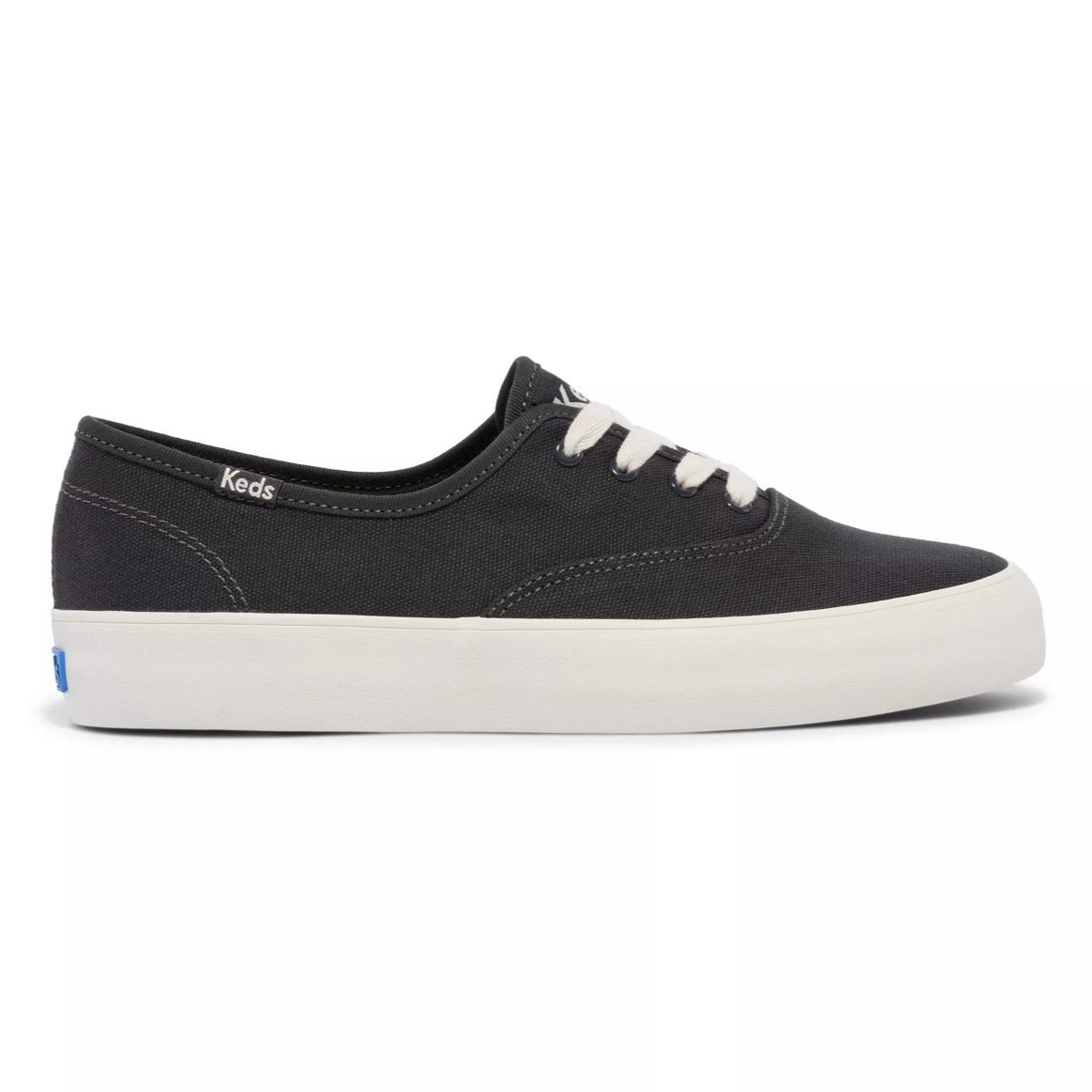 A black canvas sneaker with white laces and a white rubber sole, featuring the \“Keds\“ branding on the side.