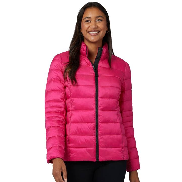 A woman is wearing a vibrant pink, lightweight, quilted packable jacket from 32 Degrees. The jacket has a high collar and a black zipper, ideal for layering and travel.
