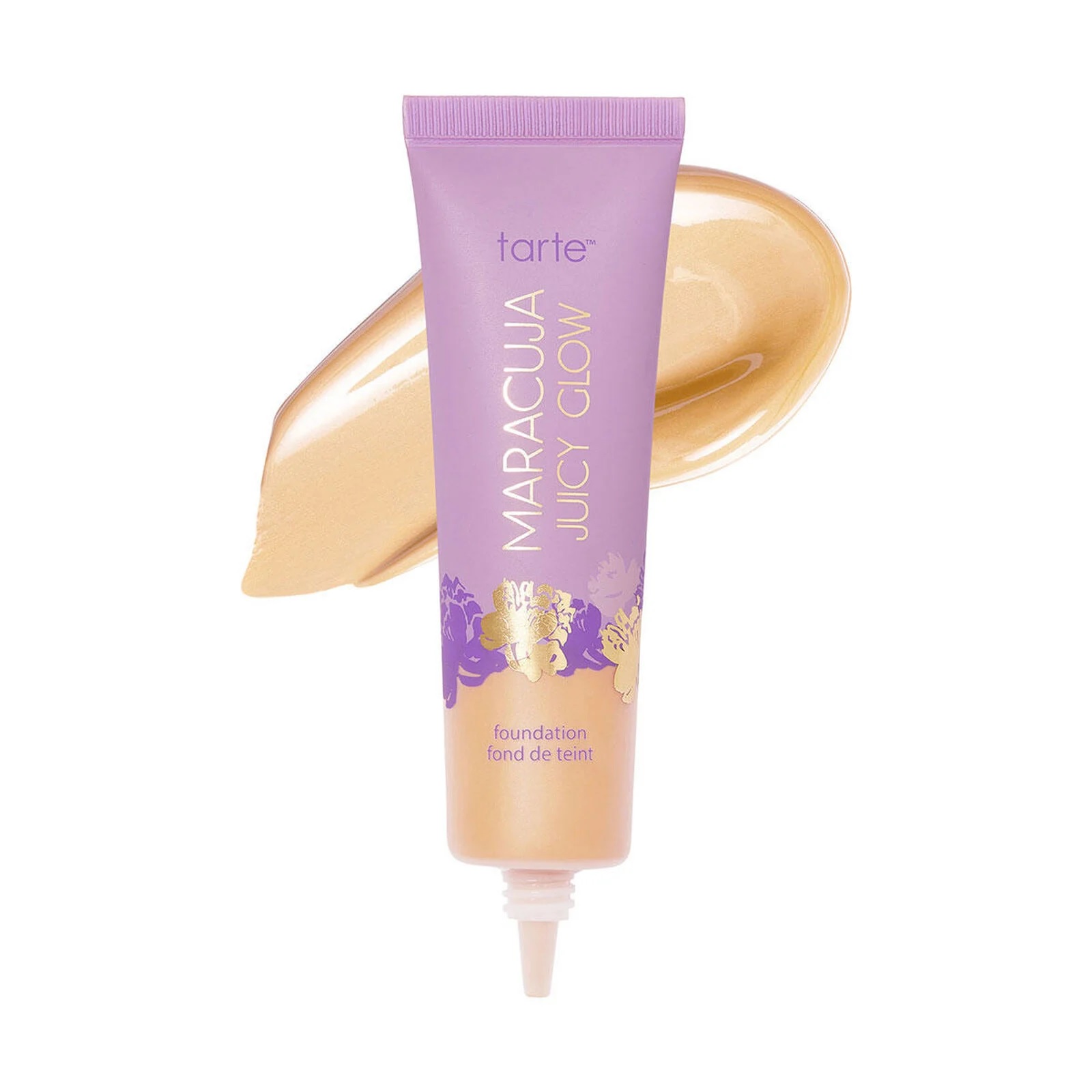 Tarte Maracuja Juicy Glow foundation in a purple tube with golden and lavender floral design, displayed with a swipe of foundation showcasing its creamy texture.