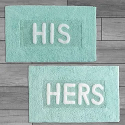 Two light blue bath mats with white text: one reads \“HIS\“ and the other \“HERS.\“