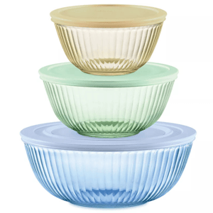 Three stacked ribbed glass mixing bowls in yellow, green, and blue, each with a coordinating plastic lid in matching colors.
