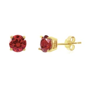 Gold-flashed silver stud earrings feature round red gemstones in prong settings, with butterfly backings for secure wear.