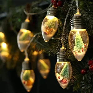 String lights featuring bulb-shaped ornaments with miniature snow scenes inside, including tiny trees and candy canes, illuminated with soft, warm lighting.