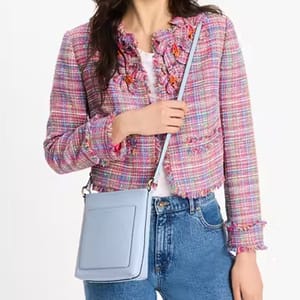 A small, structured, light blue crossbody bag with a streamlined design and adjustable strap.