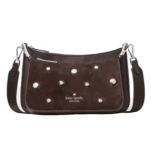 A brown Kate Spade New York shoulder bag featuring a suede texture, silver studs, and a detachable strap with silver hardware.
