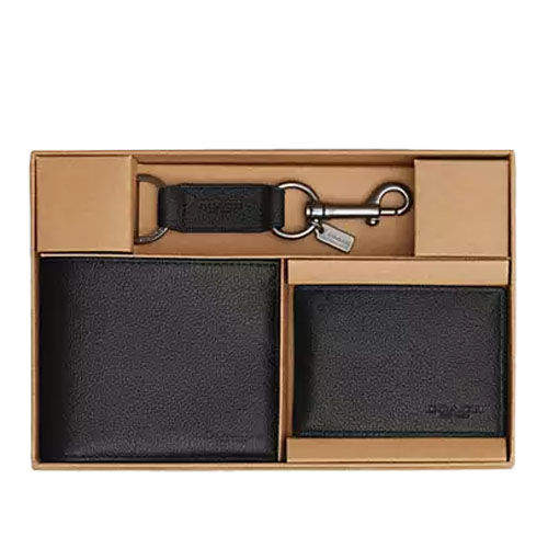 A gift set includes a black leather wallet, a cardholder, and a keychain with a metal clasp, presented in a brown box.