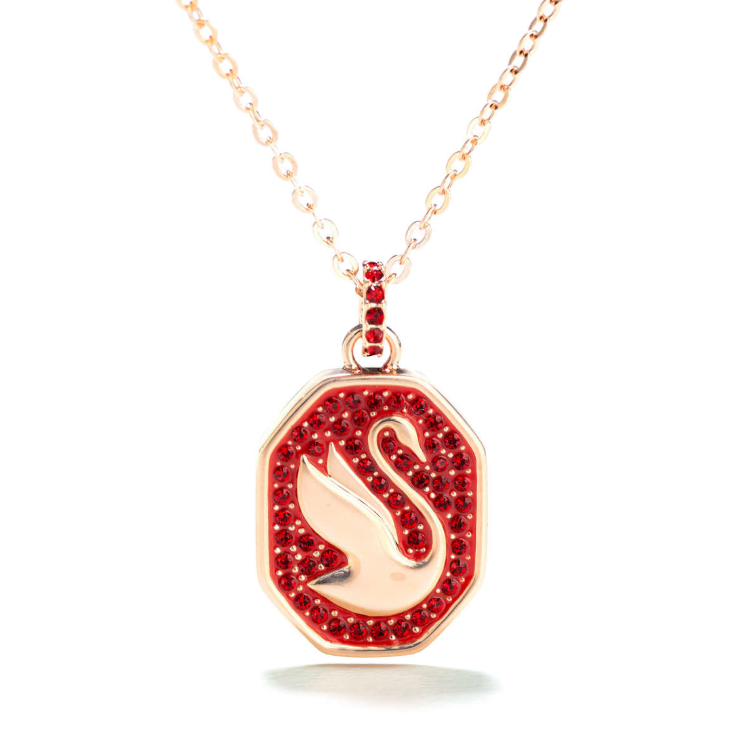 Necklace with a pendant featuring a swan design, surrounded by red crystals, set in a gold-tone metal. The chain is delicate with a matching gold-tone.