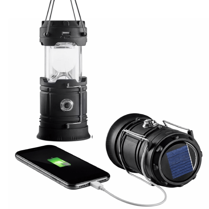 A black solar-powered lantern with a USB port for charging devices, shown hanging and lying on its side, with a smartphone connected and charging.
