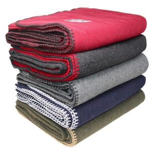 A stack of camping blankets featuring varying colors, including red, dark gray, light gray, navy blue, and olive green. The blankets have visible stitching along the edges and are made of a wool blend.