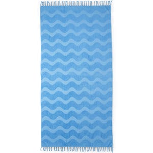 A blue towel with wavy patterns and tassels along the edges.