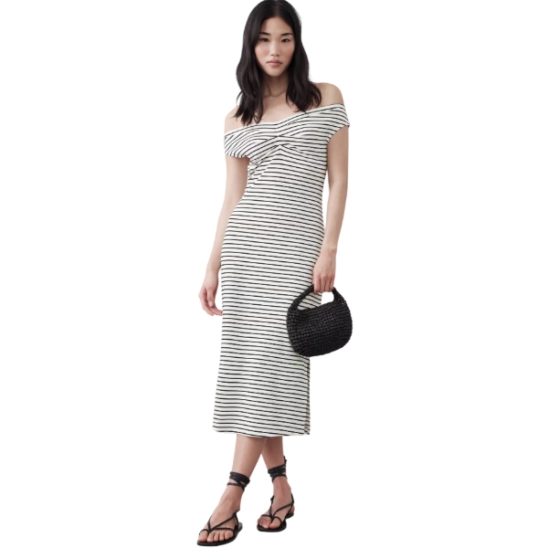 A woman is wearing a striped, off-the-shoulder midi dress paired with black sandals, holding a black woven bag.