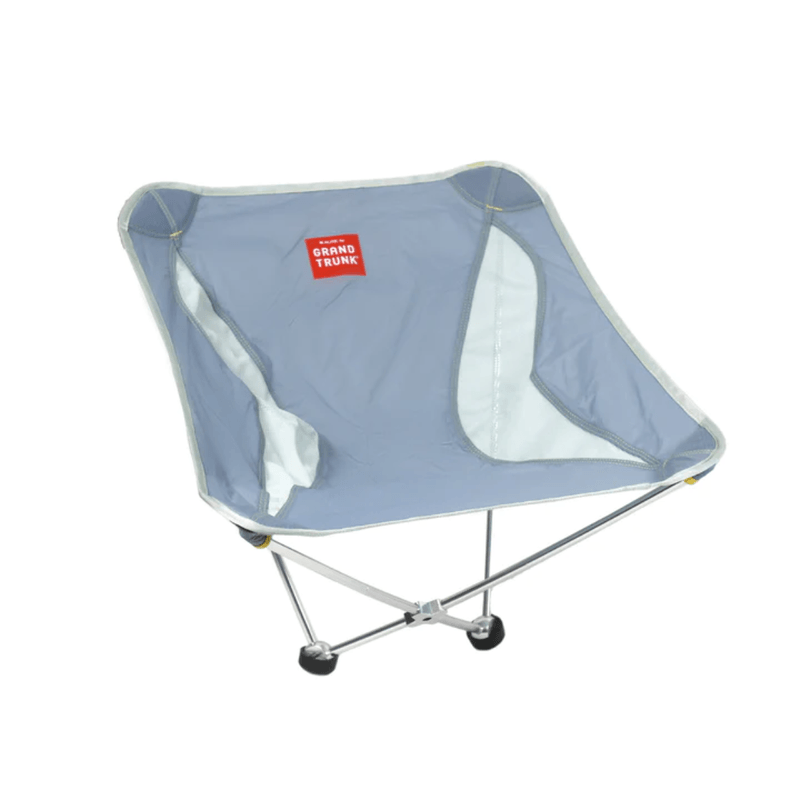 A blue, lightweight, compact Grand Trunk Monarch Chair with a collapsible frame and mesh side storage pocket.
