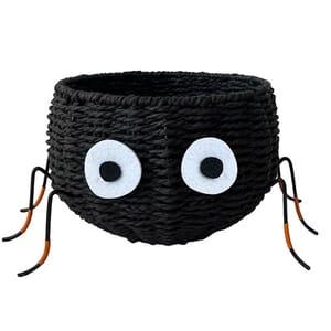 A black woven basket with large white eyes and bendable wire legs resembling a spider, suitable for decorative use.