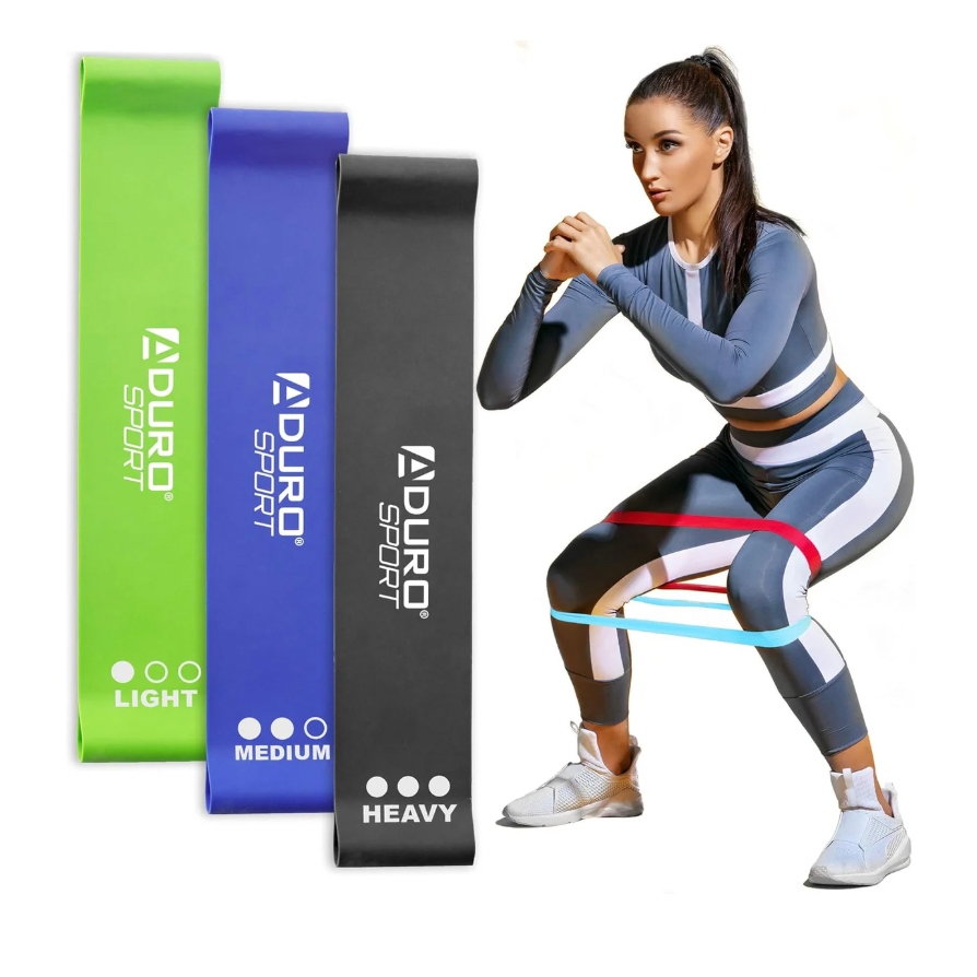 The image displays three Duro Sport resistance bands in light, medium, and heavy strengths. They're shown in green, blue, and black colors, with a person performing squats using the bands.