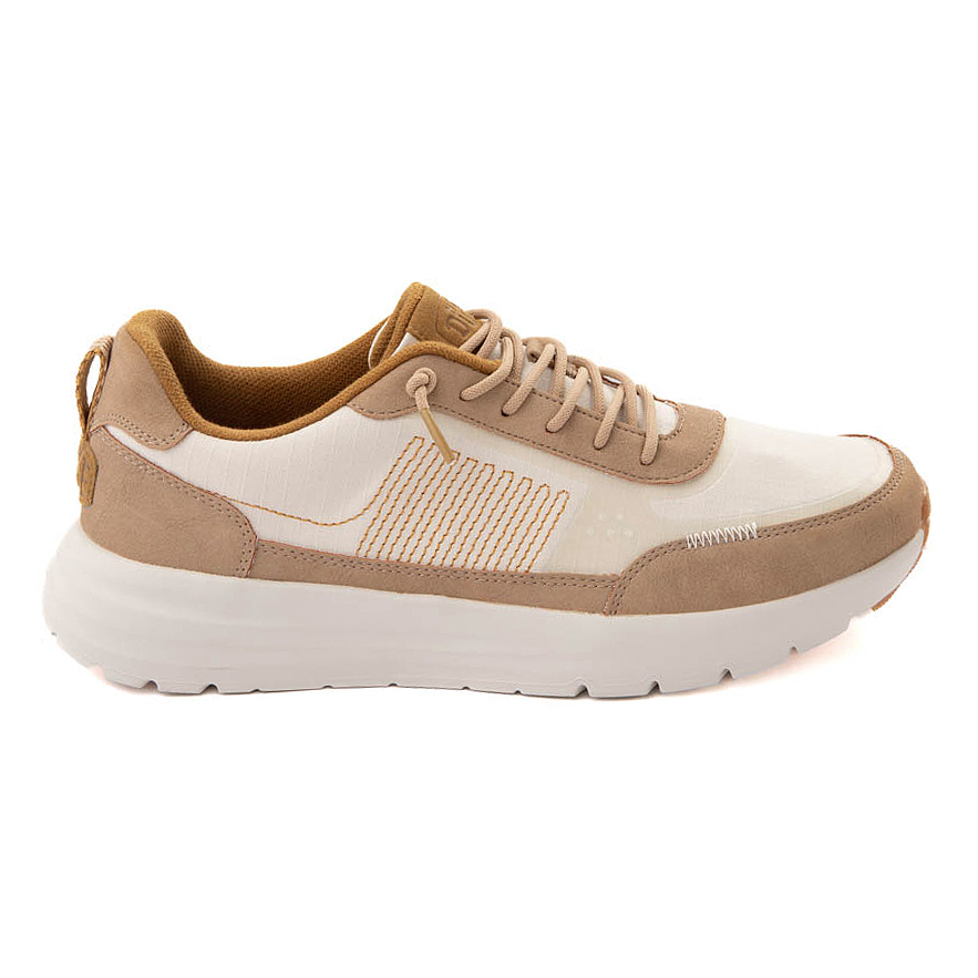 A casual sneaker featuring a cream and tan color scheme with suede accents, detailed stitching, and a chunky white sole.