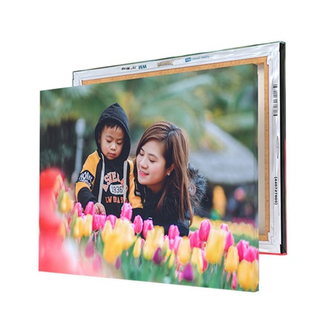 A custom canvas print displays a mother and child surrounded by colorful tulips. The print is mounted on a wooden frame, adding depth and a gallery-style appearance.