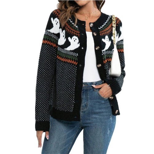 A black cardigan featuring a playful ghost pattern design, worn over a white top and paired with jeans.