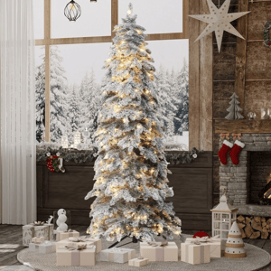 A snowy, pre-lit Christmas tree stands in a cozy, decorated living room with a fireplace, surrounded by wrapped gifts.