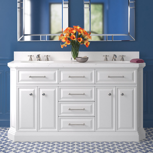 White double vanity with marble countertop, two sinks, and chrome faucets, set against a blue wall with geometric floor tiles.