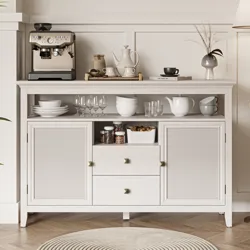 A kitchen cabinet holds a coffee machine, glassware, bowls, white jars, nuts, a teapot, cups, and decorative items, featuring a light wood finish and woven panel doors.
