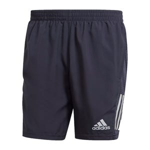 The Adidas Own the Run Shorts are navy with a relaxed fit, featuring an elastic waistband, side pockets, and the Adidas logo on the left leg. They include signature three-stripe detailing on the sides.