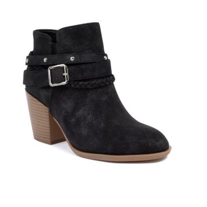 Black ankle boot with a stacked heel, featuring decorative straps with a buckle and a braided detail.