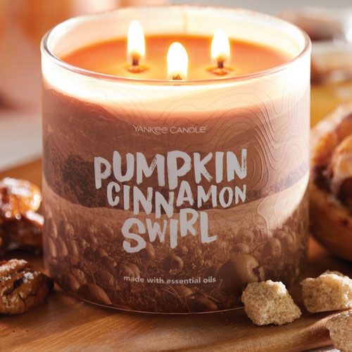 a lit 3-wick Yankee Candle pumpkin cinnamon swirl candle surrounded by pecans and pastry crumbs