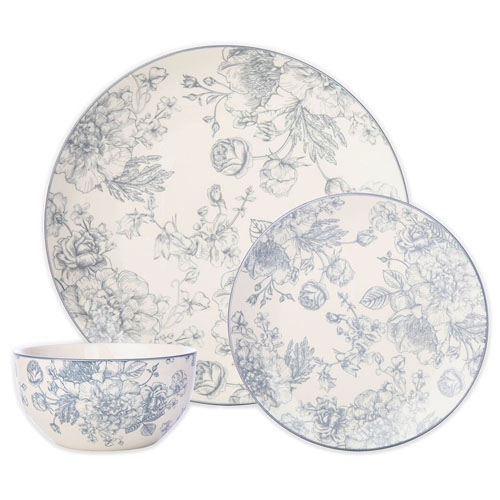 A dinnerware set featuring floral designs in blue on cream, including a large plate, a small plate, and a bowl.