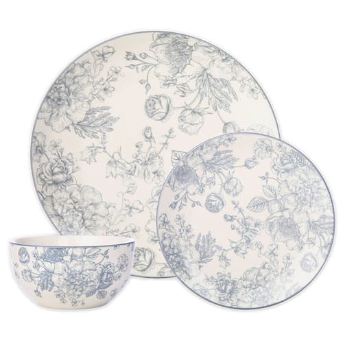A dinnerware set featuring floral designs in blue on cream, including a large plate, a small plate, and a bowl.