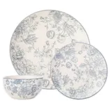 A dinnerware set featuring floral designs in blue on cream, including a large plate, a small plate, and a bowl.