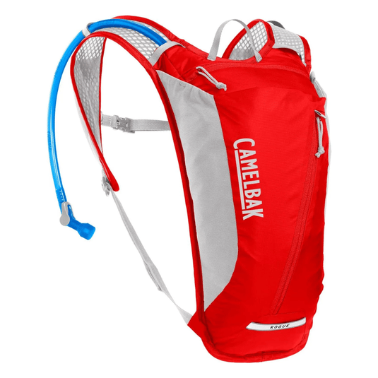 A red CamelBak Rogue hydration pack with a blue drinking tube, designed for carrying water during outdoor activities like hiking and cycling.