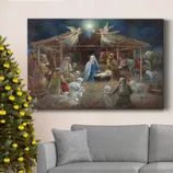 A Christmas-themed painting of the nativity scene is displayed above a gray sofa next to a decorated Christmas tree with gold ornaments.