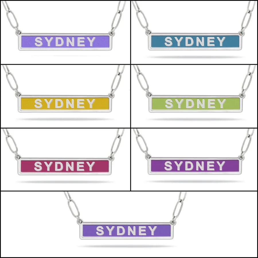 Seven necklaces with rectangular pendants featuring the name \“Sydney\“ in various colors: purple, blue, yellow, green, pink, and two shades of purple.