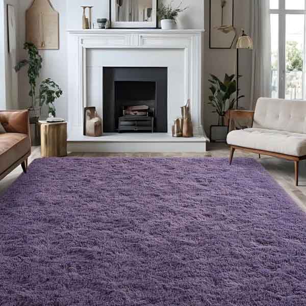 Purple shag area rug, 5' x 8', with a plush texture, placed in a cozy living room featuring a white fireplace, light-colored sofas, and indoor plants, blending modern and natural elements.