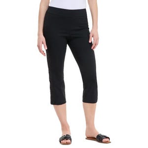 Black cropped leggings with a subtle side pattern, paired with a white top and black sandals.