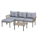 A patio furniture set featuring a three-seater wicker sectional with light blue cushions, an ottoman, and a matching rattan coffee table with black metal legs.