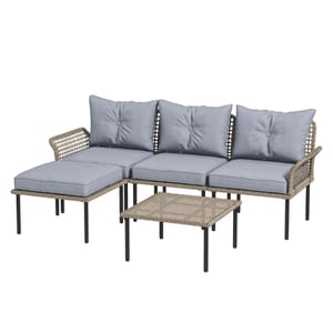 A patio furniture set featuring a three-seater wicker sectional with light blue cushions, an ottoman, and a matching rattan coffee table with black metal legs.