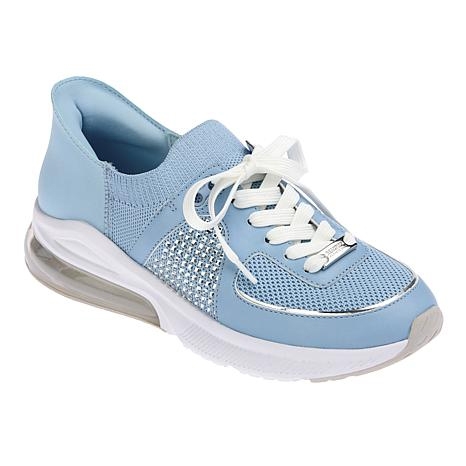 Kenneth Cole Jenna Jewel Sneakers are light blue with a breathable mesh design, white laces, and a gem-studded side detail. They feature a transparent air cushion in the heel for added comfort.