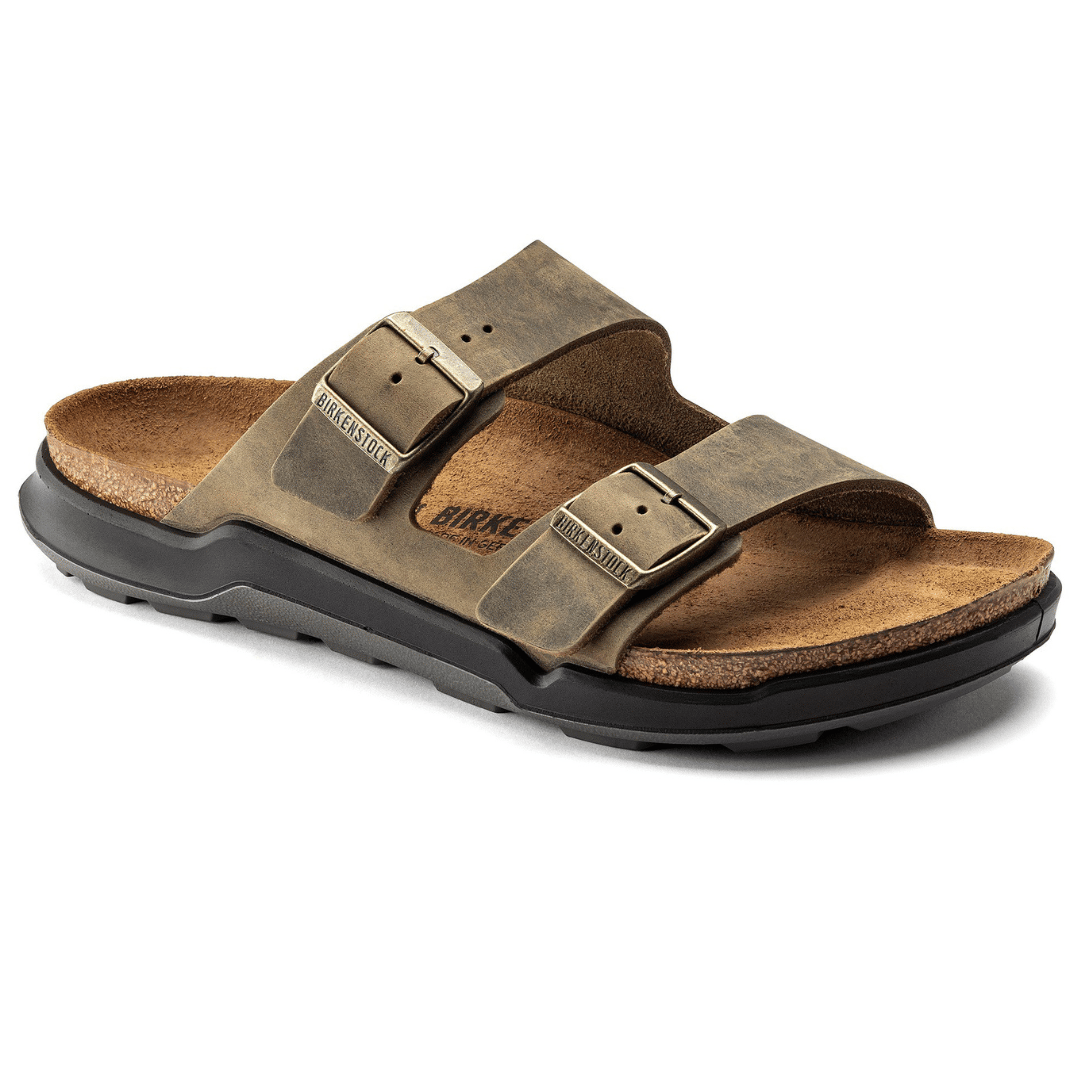 Sandals with a cork footbed, two adjustable brown straps, metallic buckles, and a black sole.