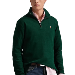 Forest green Polo Ralph Lauren 1/4-zip pullover featuring long sleeves, a high collar, and the signature logo embroidered on the chest; styled over a pink shirt with jeans.