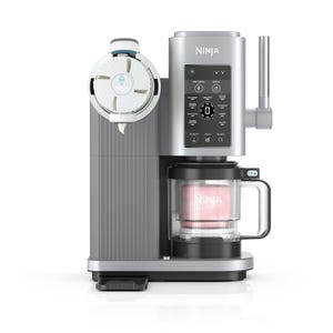 Ninja ice cream maker with digital controls, capable of making soft serve, ice cream, and gelato. Includes a container and lid for mixing and serving.
