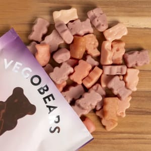 10pk Organic Gummy Bears feature soft, bear-shaped gummies in pastel colors, spilling from a partially visible purple and white package labeled \“VEGOBEARS.\“