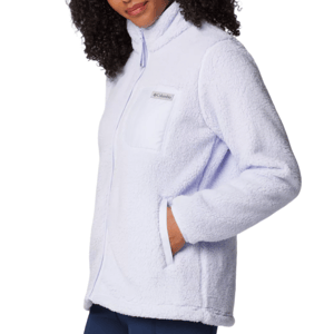 A woman is wearing a light purple Columbia fleece jacket with a high collar and zippered front, featuring a chest pocket with a logo and side pockets.
