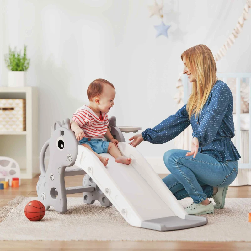A toddler plays on a small indoor slide with a horse design, accompanied by an adult.