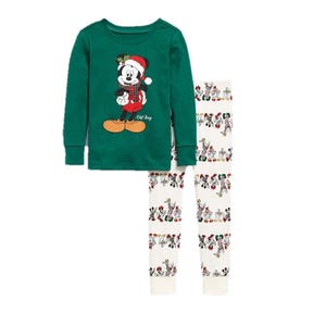 Green long-sleeve pajama top with a holiday-themed cartoon character, paired with white pajama pants featuring a repeated pattern of various cartoon characters.